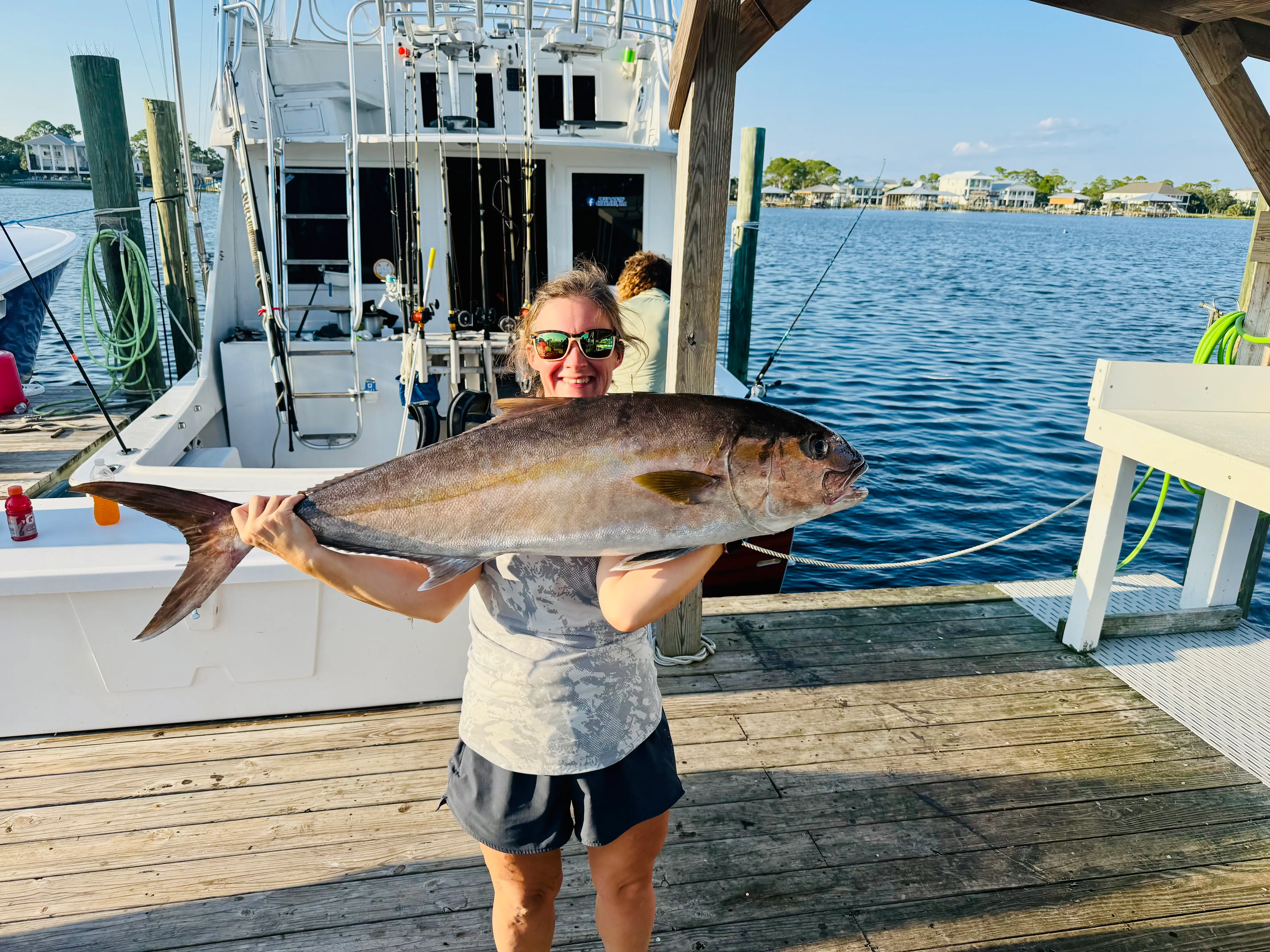 Angler holding a massive amberjack on the dock after Deep South Charters fishing trip in Orange Beach Alabama
