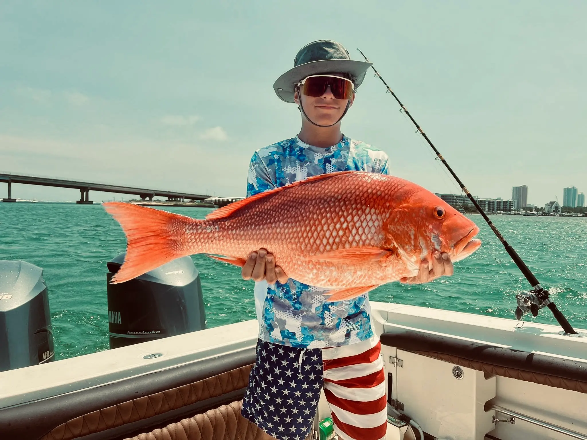 Young angler holding a large red snapper on Deep South Charters fishing trip in Orange Beach Alabama
